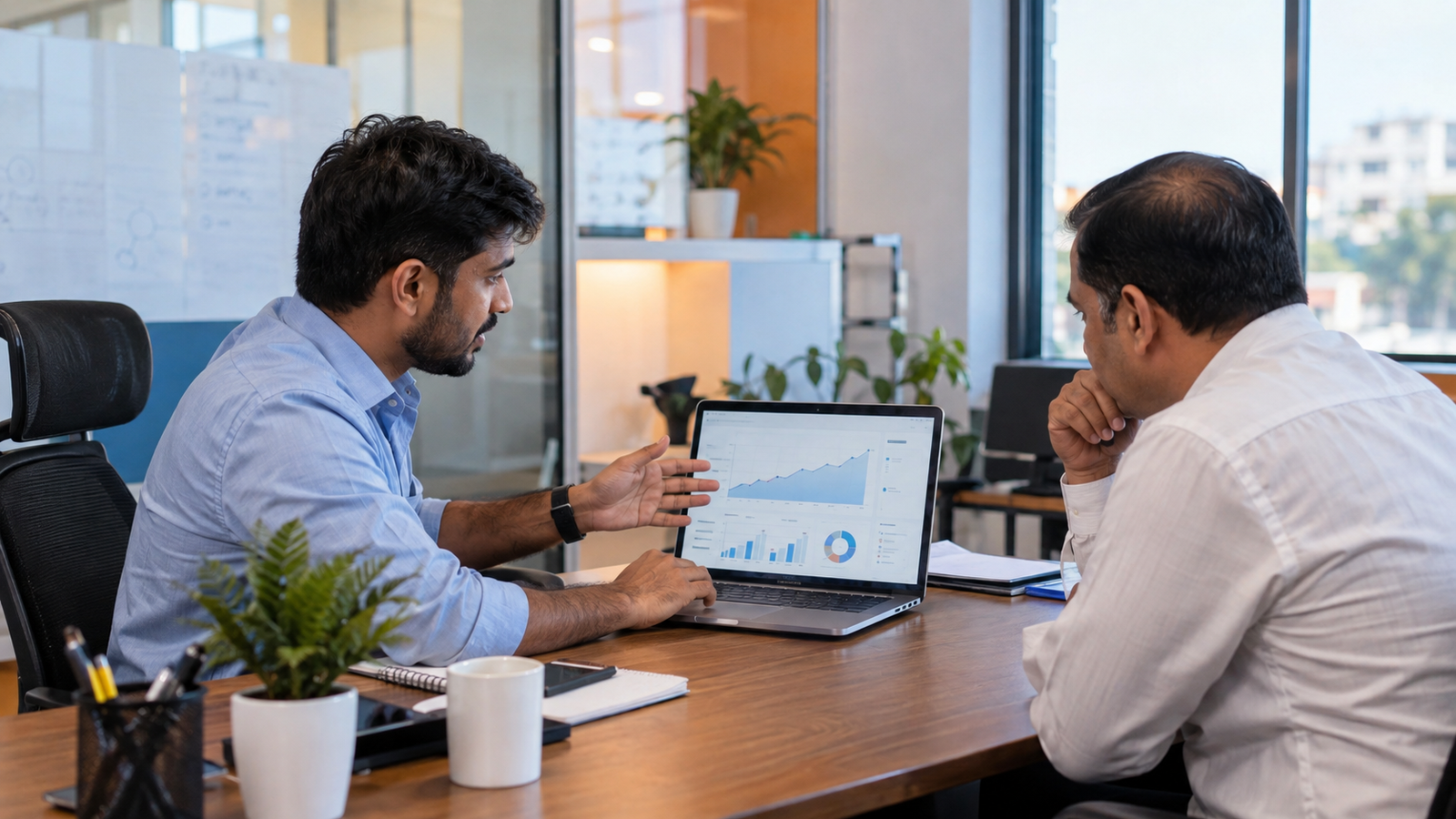 Alt text: Indian SEO consultant discussing website optimization and organic search performance with a business owner in Patna.